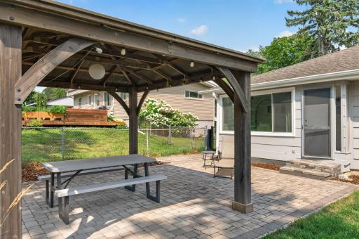 The sunroom flows to the brick patio and pergola