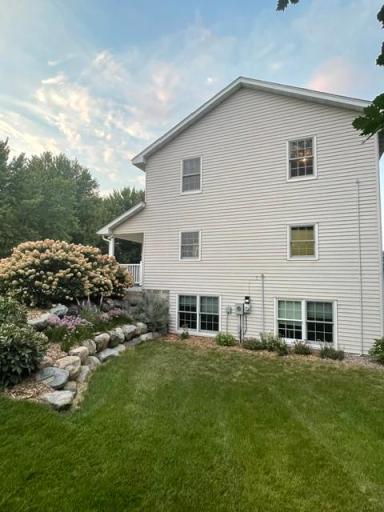 Side view of the home with daylite windows to bedroom and exercise room, plus well landscaped off front porch
