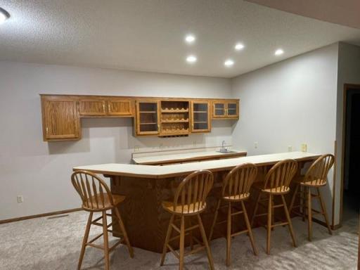 Lower level bar/ or second kitchen space. Seating for 6, highlited with recess lighting- plus lots of storage just off family room.
