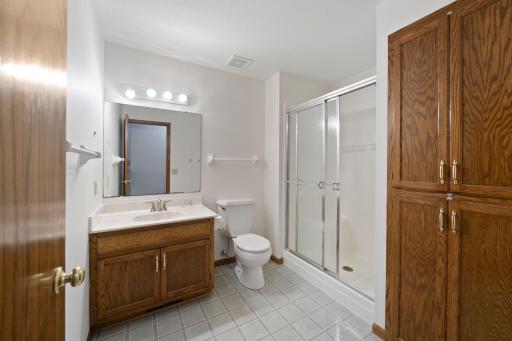 Lower level 3/4 bath with shower/ shower door and linen cabinet