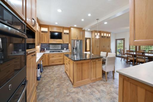 A "few" of the "extra features" throughout the cabinetry: Raised dishwasher eliminates bending down, pull out space racks in center island baking center, plus pop up mixer feature. Detailed lighting options throughout kitchen