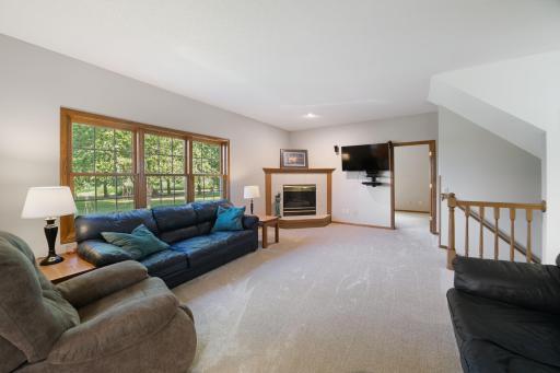 Main level family room with gas fireplace, situated between the kitchen and office space