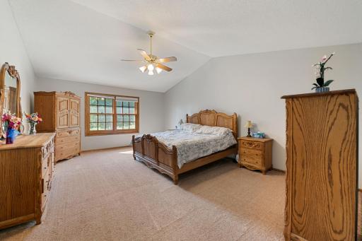 Vaulted primary bedroom with ceiling fans.