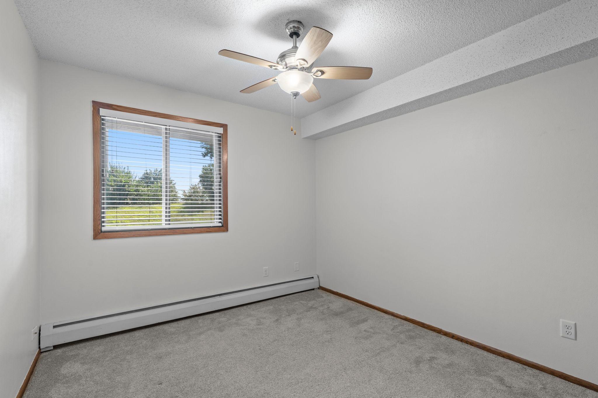 Bedroom two is located next to the primary bedroom. Both bedrooms offer ceiling fans and ample closet space.