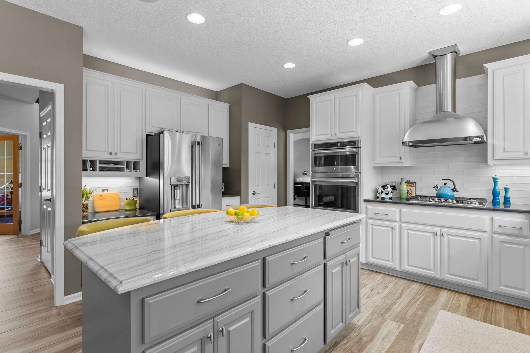 The kitchen is also equipped with stainless steel appliances, including a gas cooktop and stainless steel hood vented to the exterior.