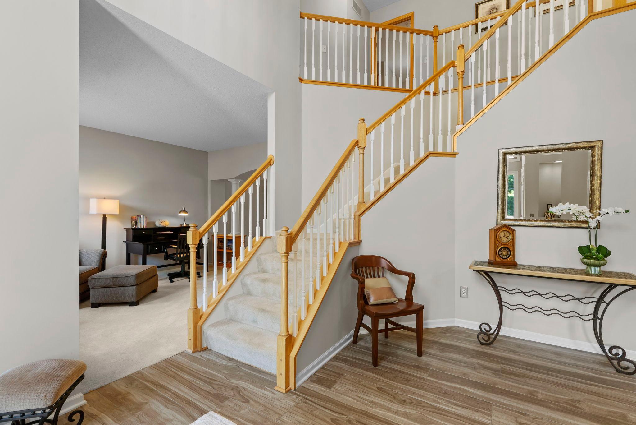 As you enter, you are greeted by an inviting foyer featuring soaring 18-foot ceilings, a spacious entry closet, and a staircase leading to the upper level.