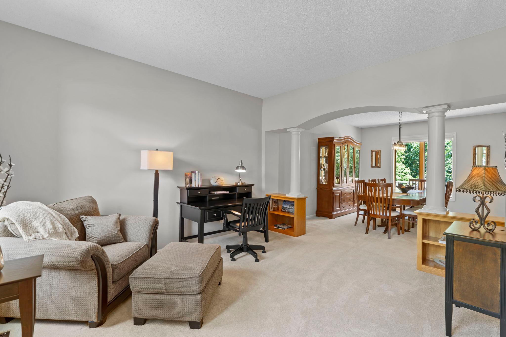 The sitting room features new carpeting and large front-facing windows that fill the space with natural light.
