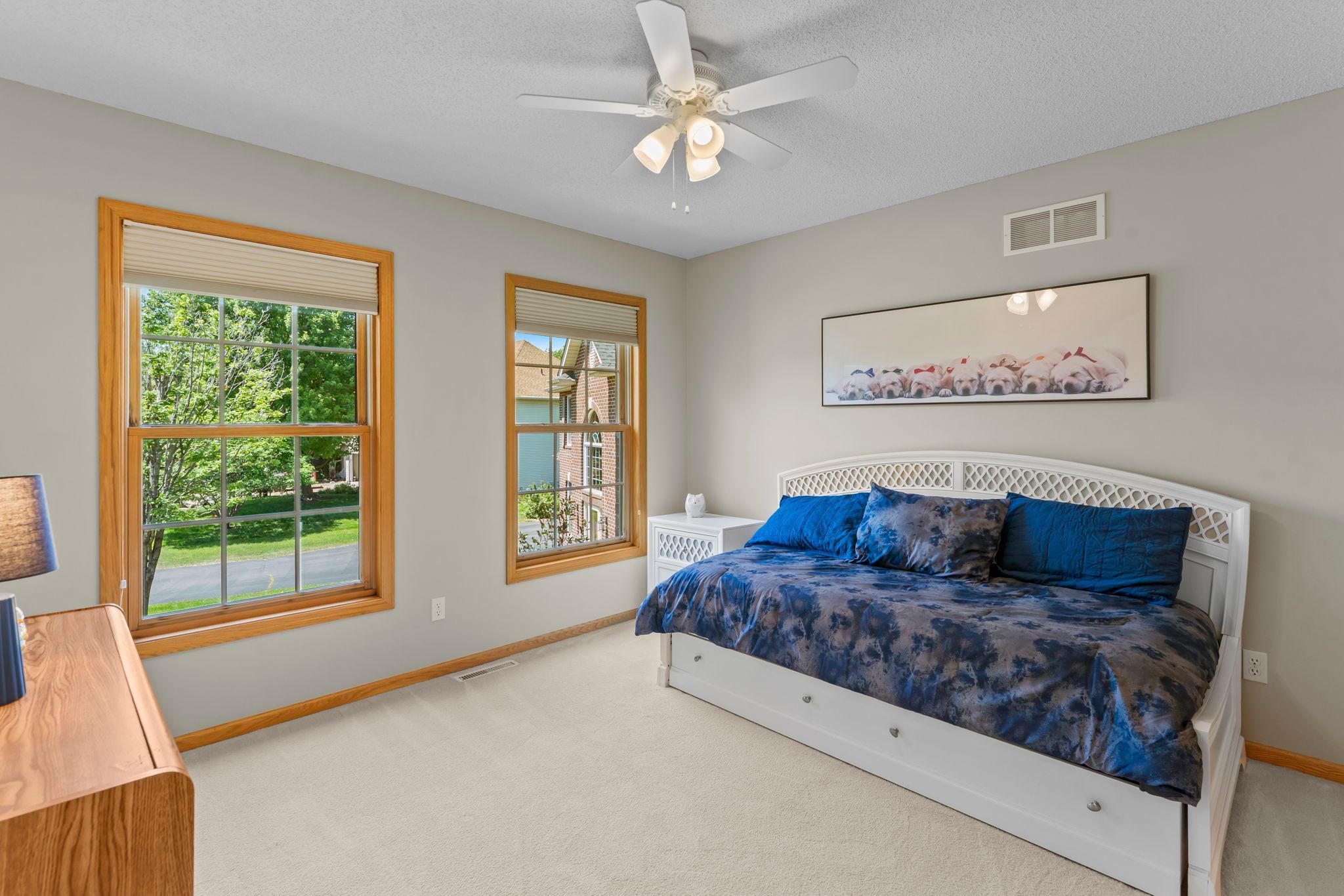 Upper-level bedroom four features large front-facing windows, a ceiling fan, new carpeting, a walk-in closet, and a shared Jack-and-Jill bathroom with bedroom three.