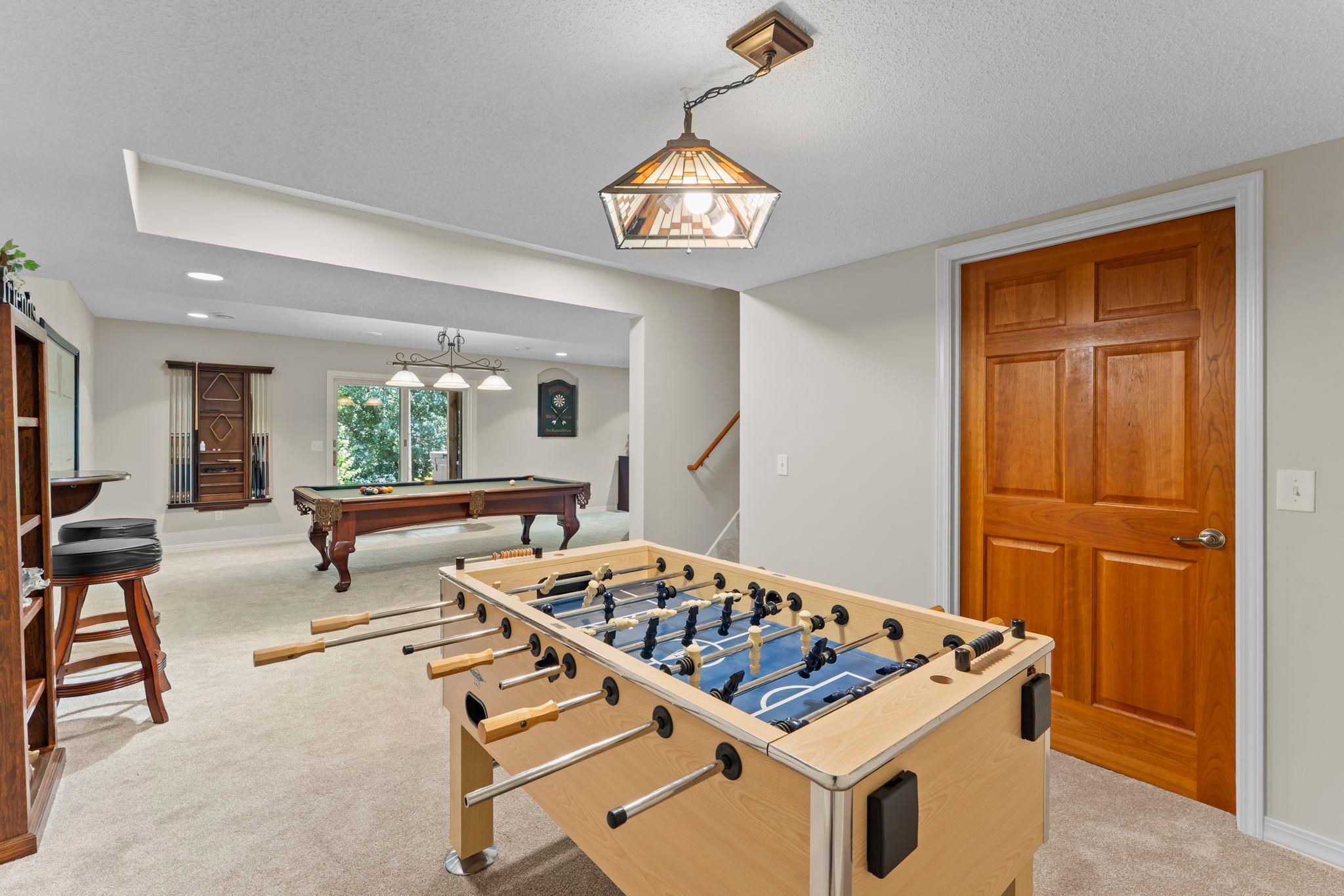 The lower level is designed for entertaining, featuring a spacious recreation room with an Anderson sliding door providing direct access to the expansive backyard patio.