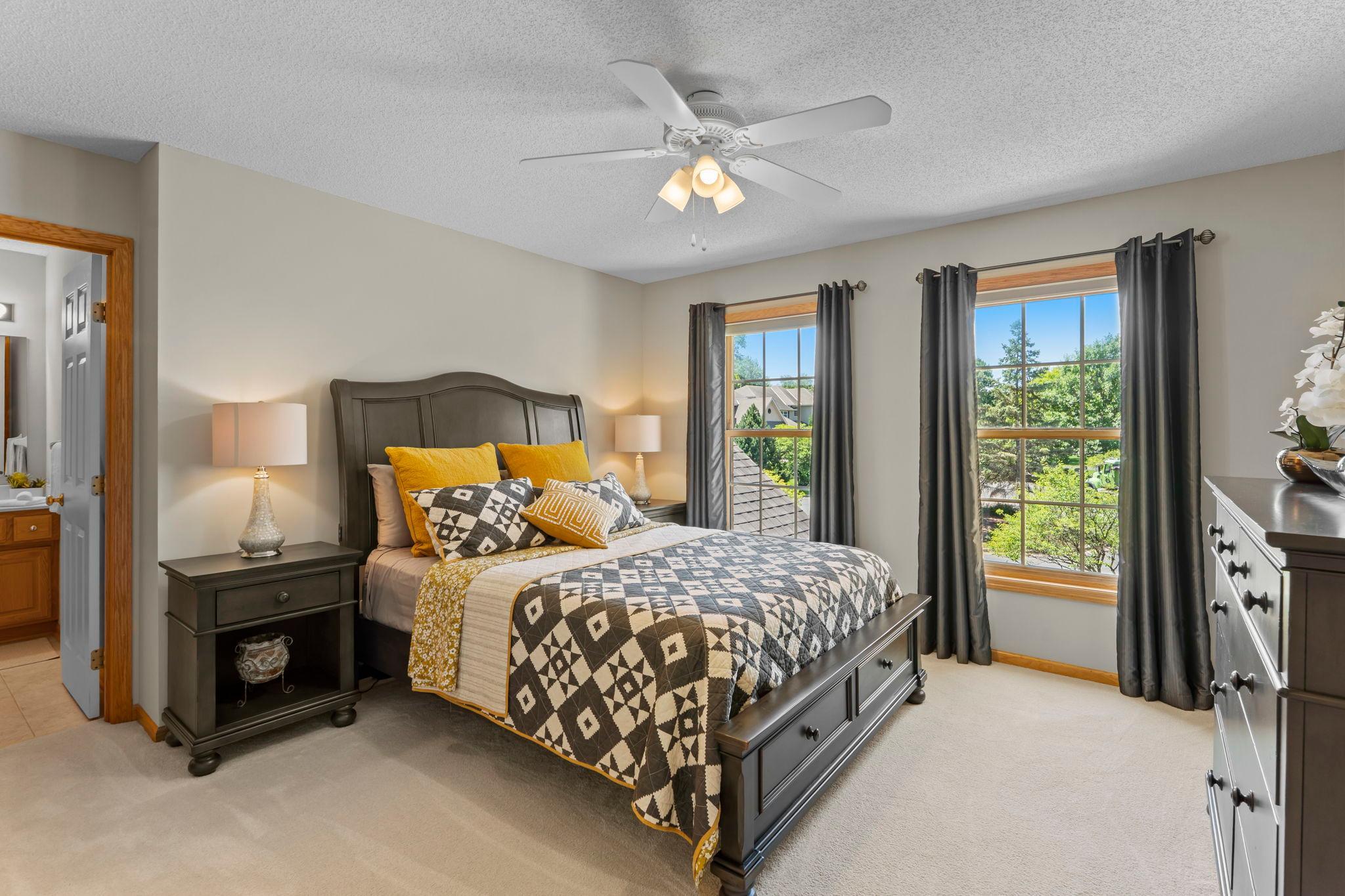 Bedroom two is generously sized and features new carpeting, a ceiling fan, 4x4 walk-in closet, and private ¾ bathroom.