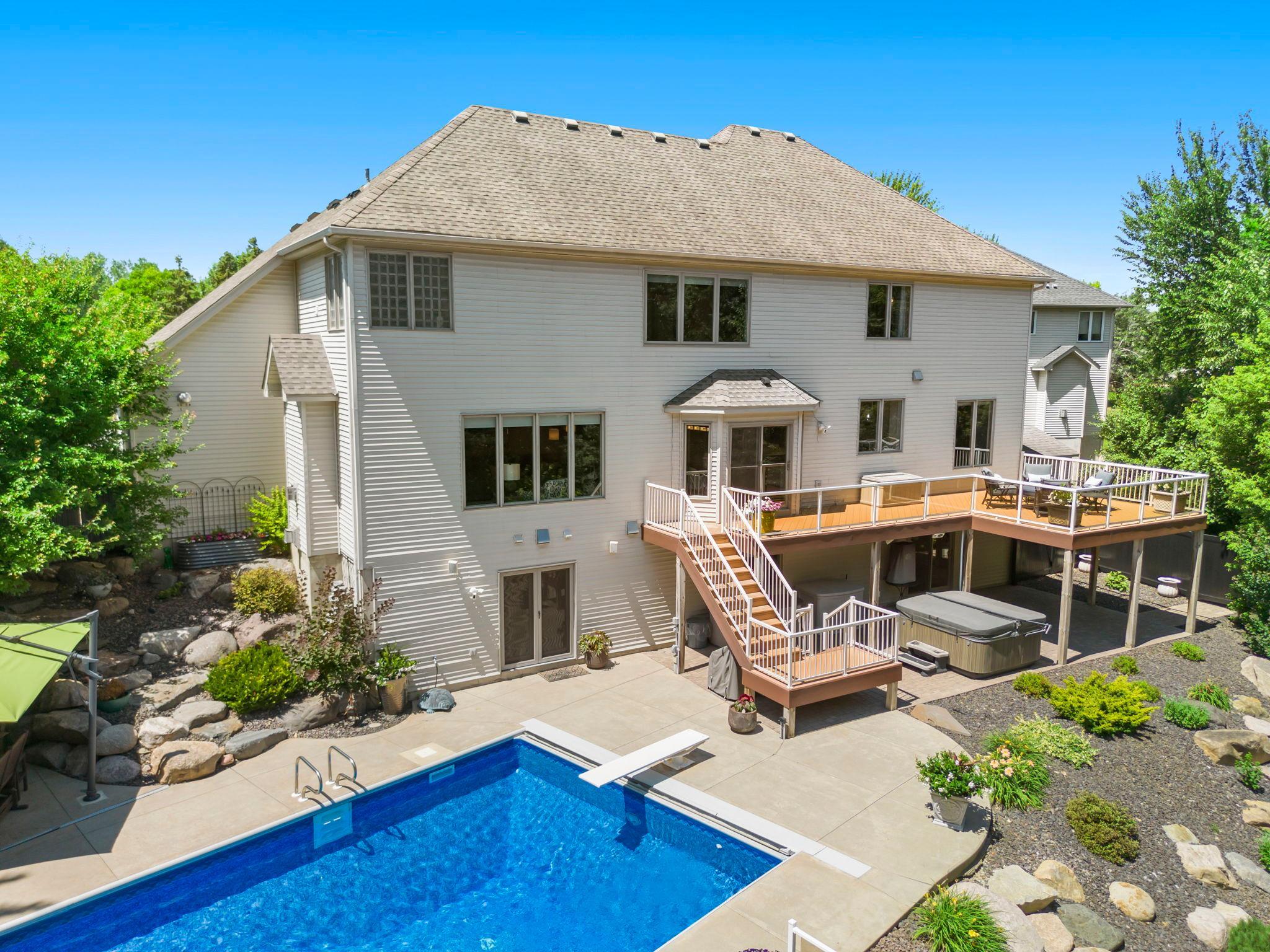 Enjoy the expansive patio with hot tub, underground heated pool, maintenance-free deck, and large pool deck with a raised secondary deck—perfect for soaking up the sun.
