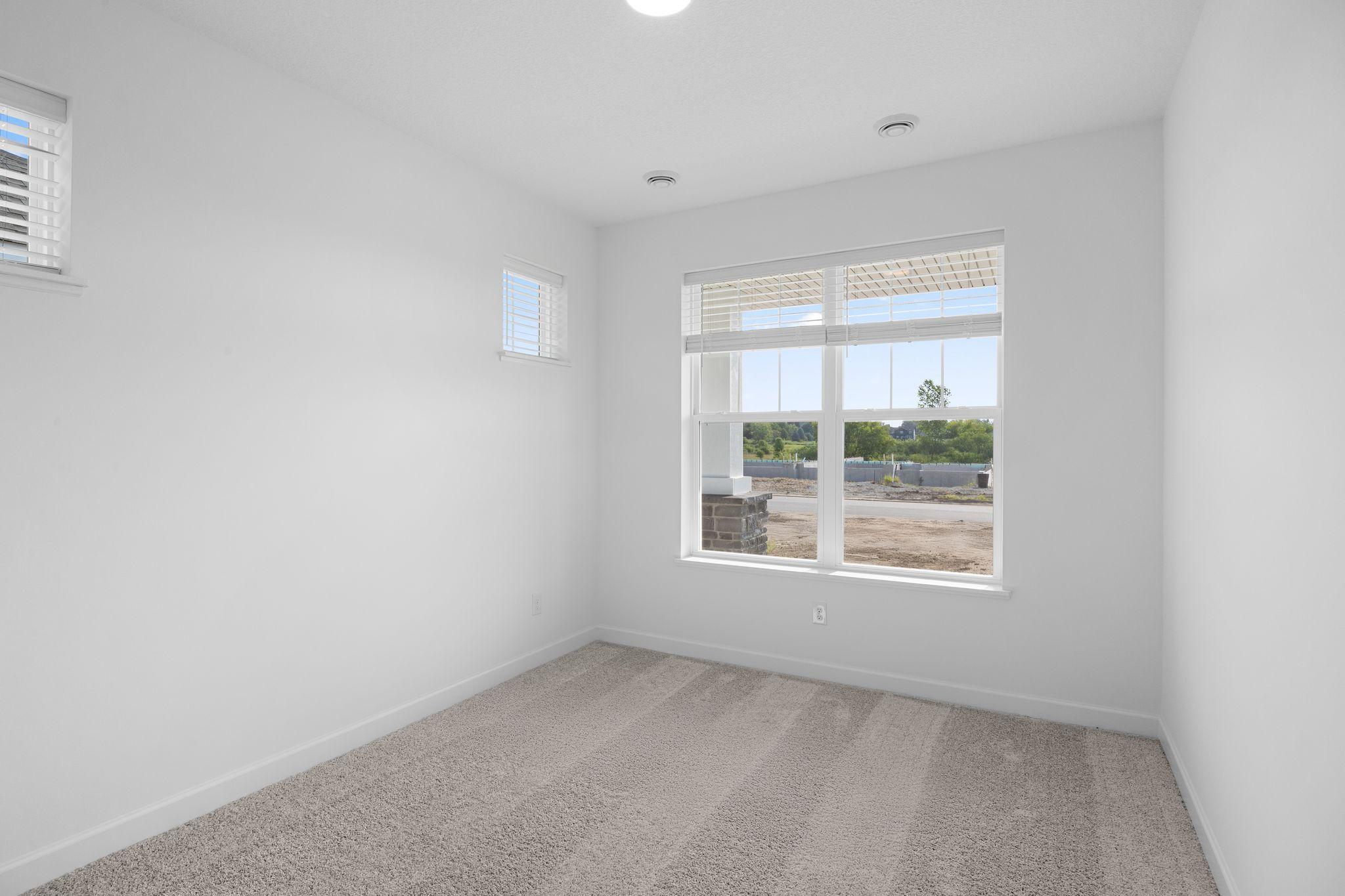 A secondary bedroom situated just off the entry is ideal as a space for overnight guests or a home office
