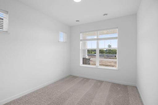 A secondary bedroom situated just off the entry is ideal as a space for overnight guests or a home office
