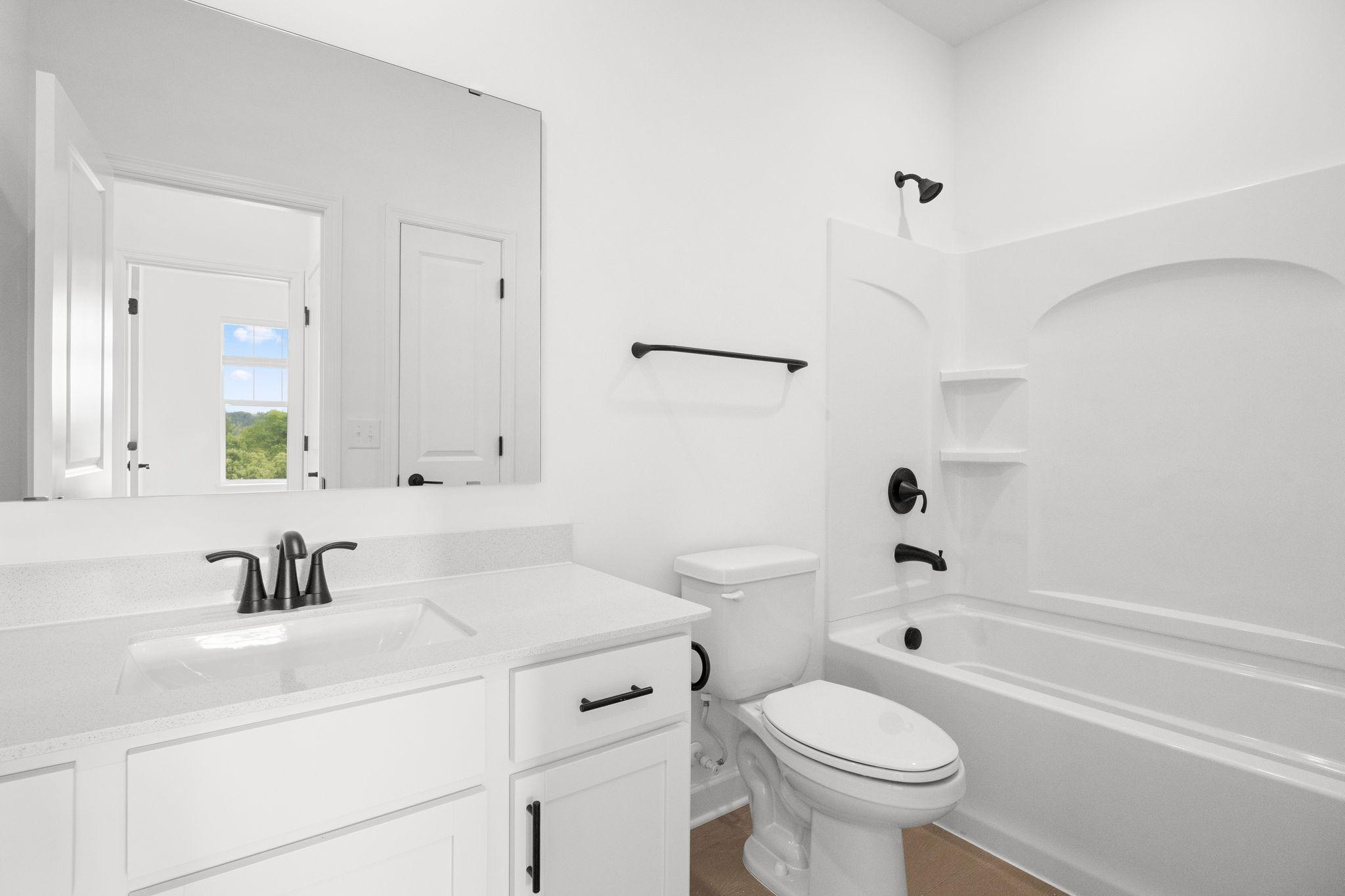 This shared full bathroom is easily accessible from the open floorplan for guest and daytime use.