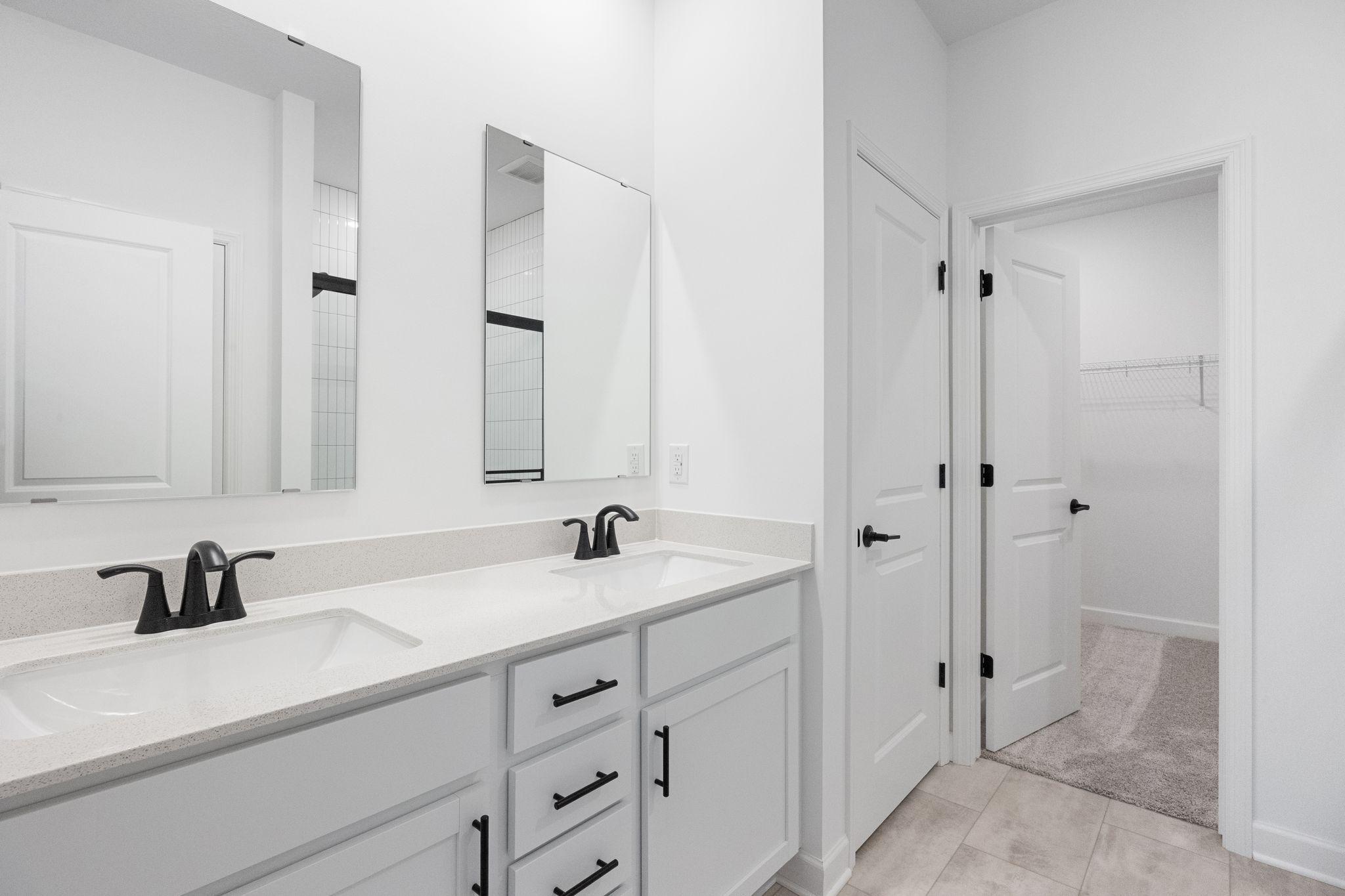 Convenient dual sinks and direct access to the walk-in closet promote a streamlined morning routine
