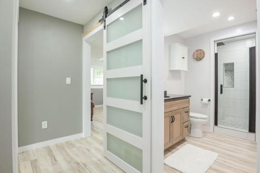 Beautiful lower-level remodeled 3/4 tiled walk in shower, custom cabinets, doors and shelving with a