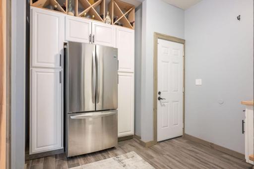 Mud Room thoughtfully designed with cabinetry, wine rack and refrigerator