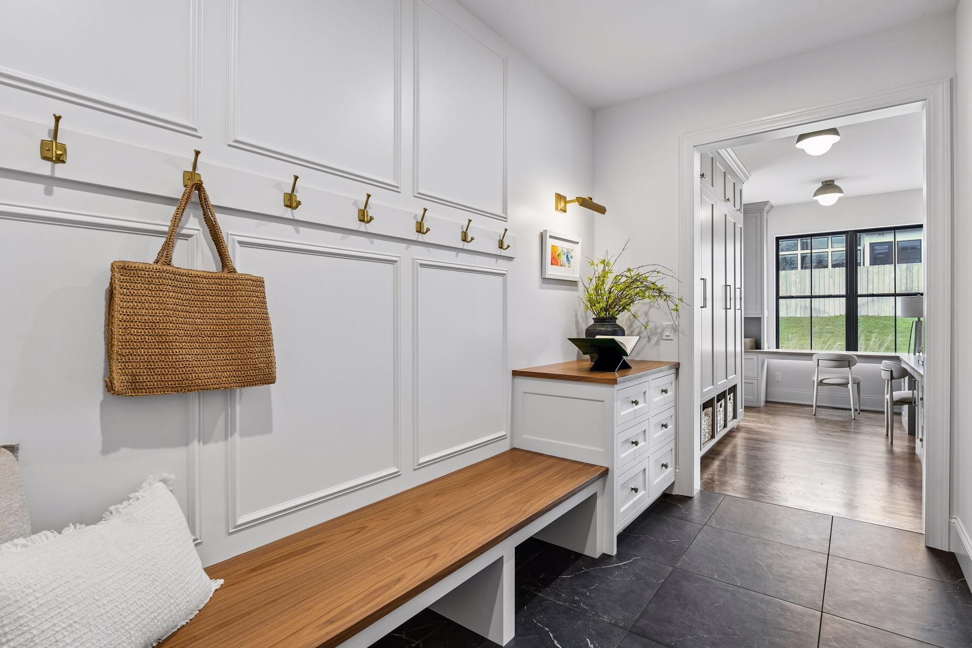 Mudroom right off the garage features oversized built in bench and dedicated drop zone