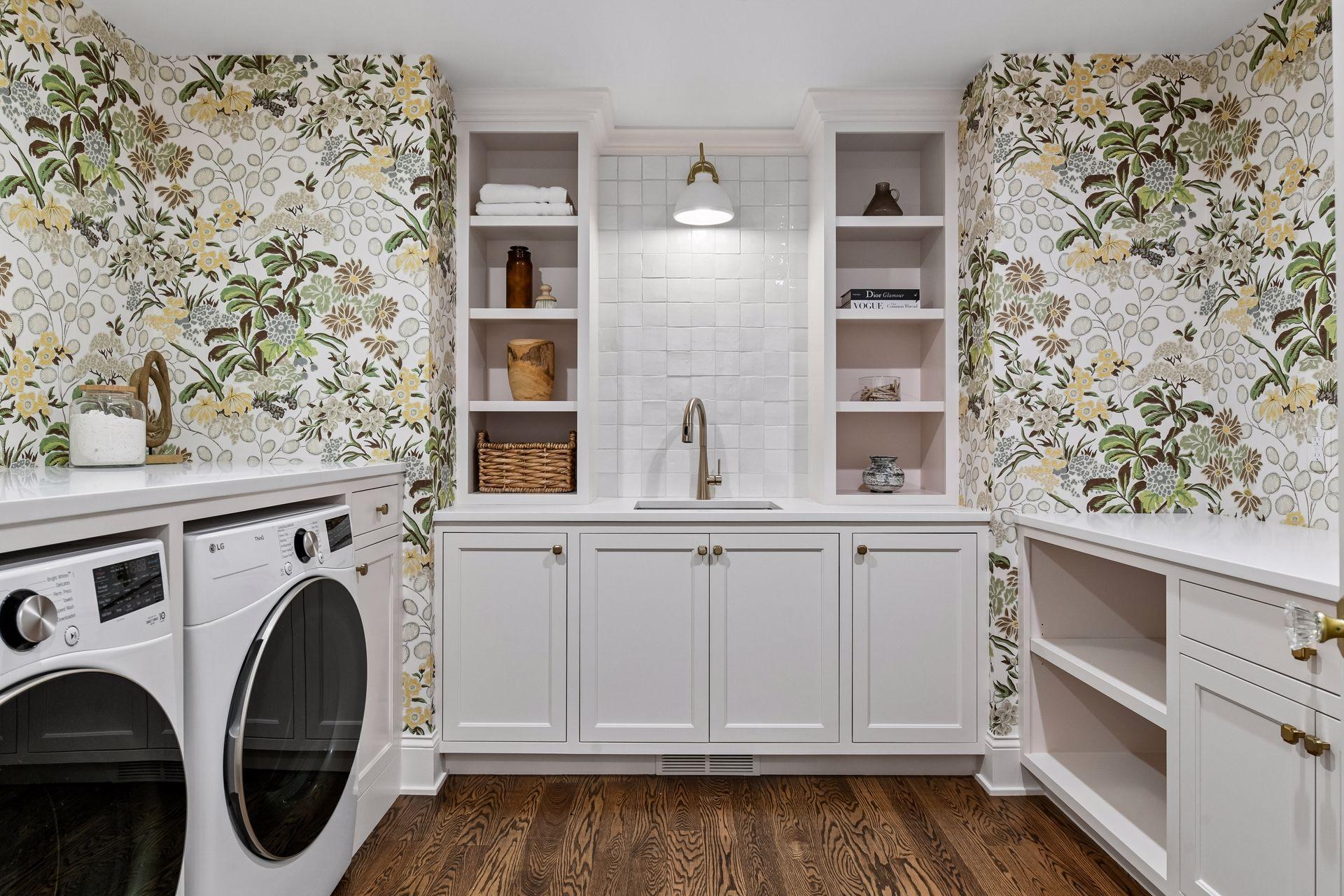 Upper level laundry room features custom wallpaper, utility sink with built ins and large folding area