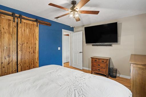 Another view of primary bedroom with barn door over closet