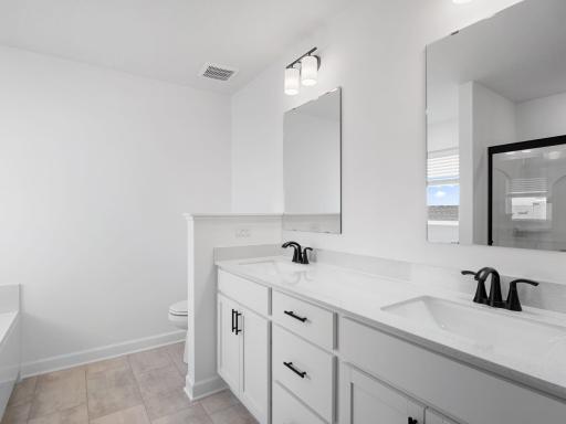 Dual sinks, a glass-enclosed shower and separate soaking tub are included in the en-suite bathroom