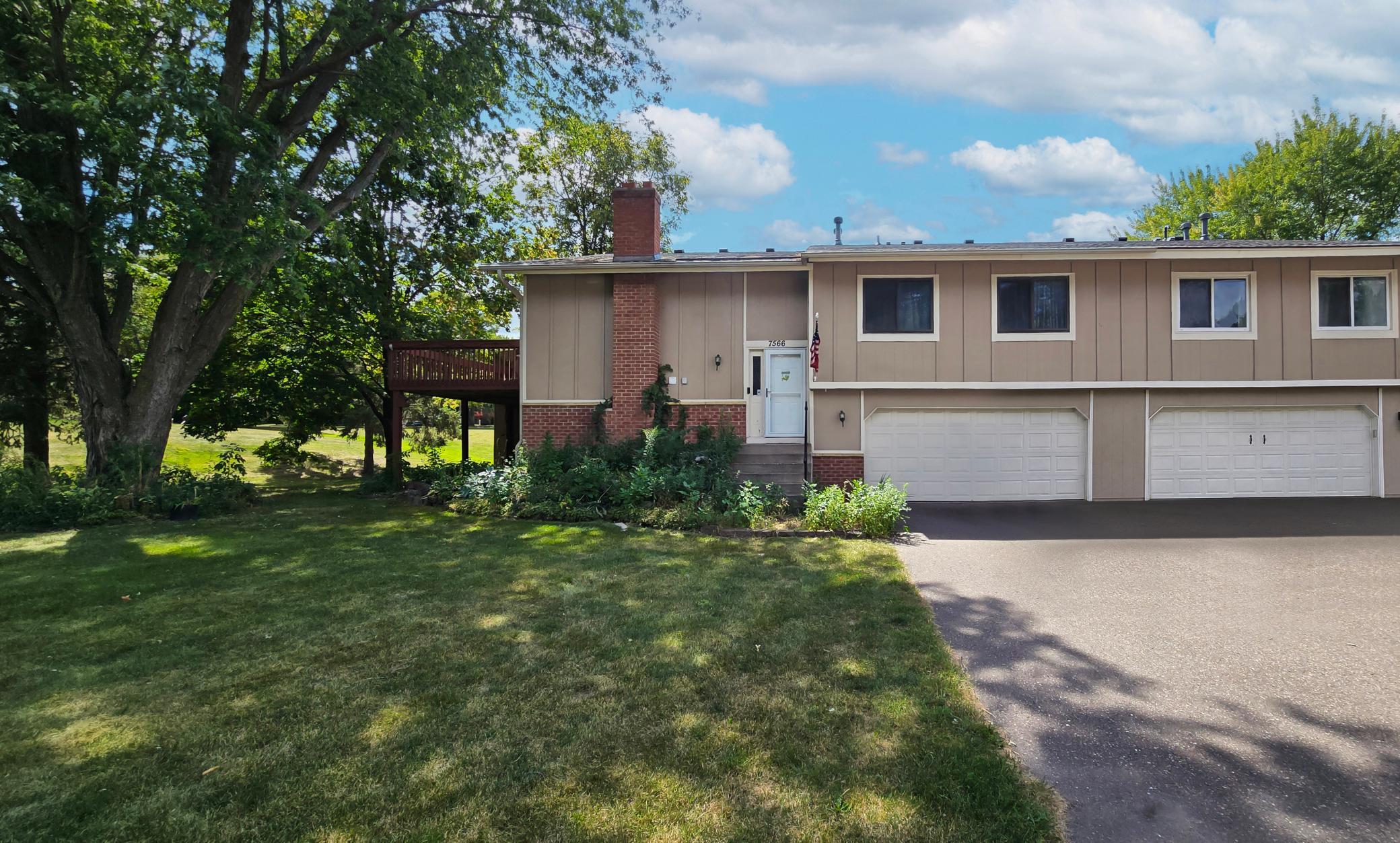Lovely curb appeal featuring mature shade trees, an attached garage, and an inviting entry.