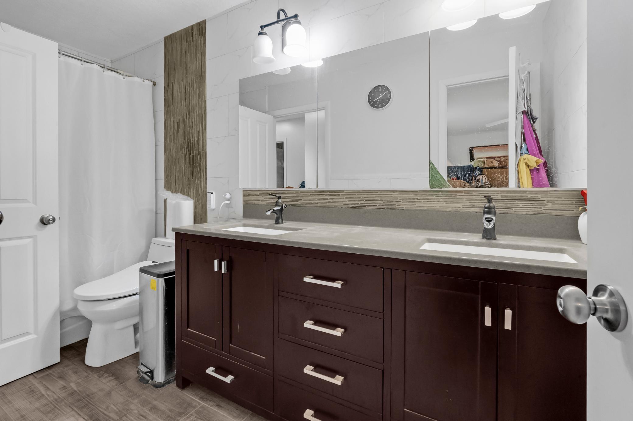 Bright primary bathroom layout offering an expansive vanity setup and dedicated bath area.