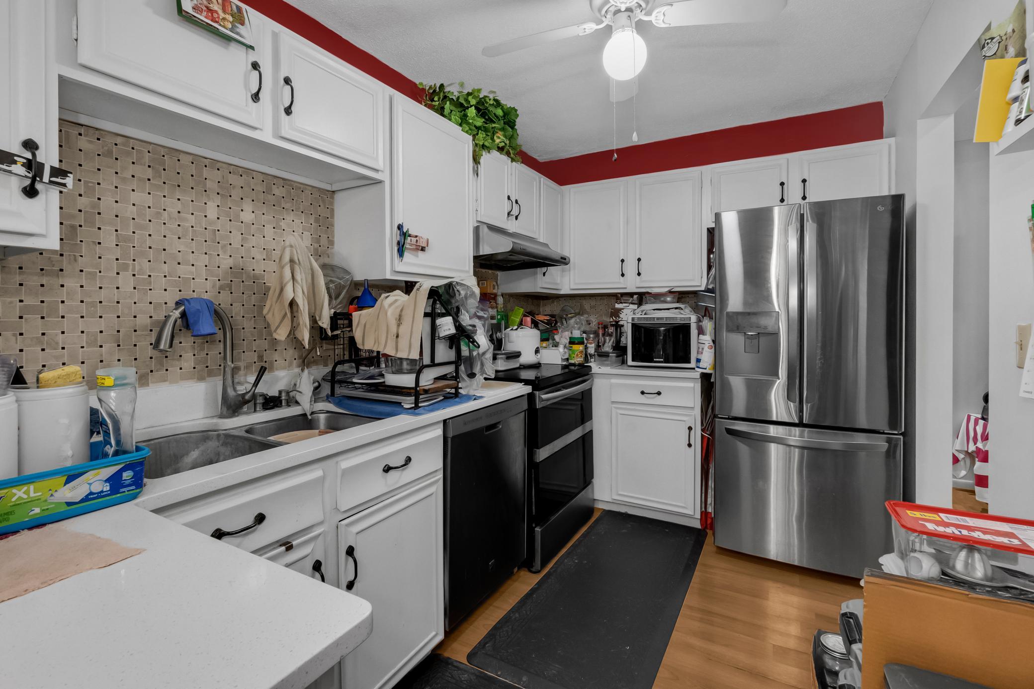 Bright kitchen equipped with stainless steel appliances, crisp white cabinetry, and plenty of counter space.