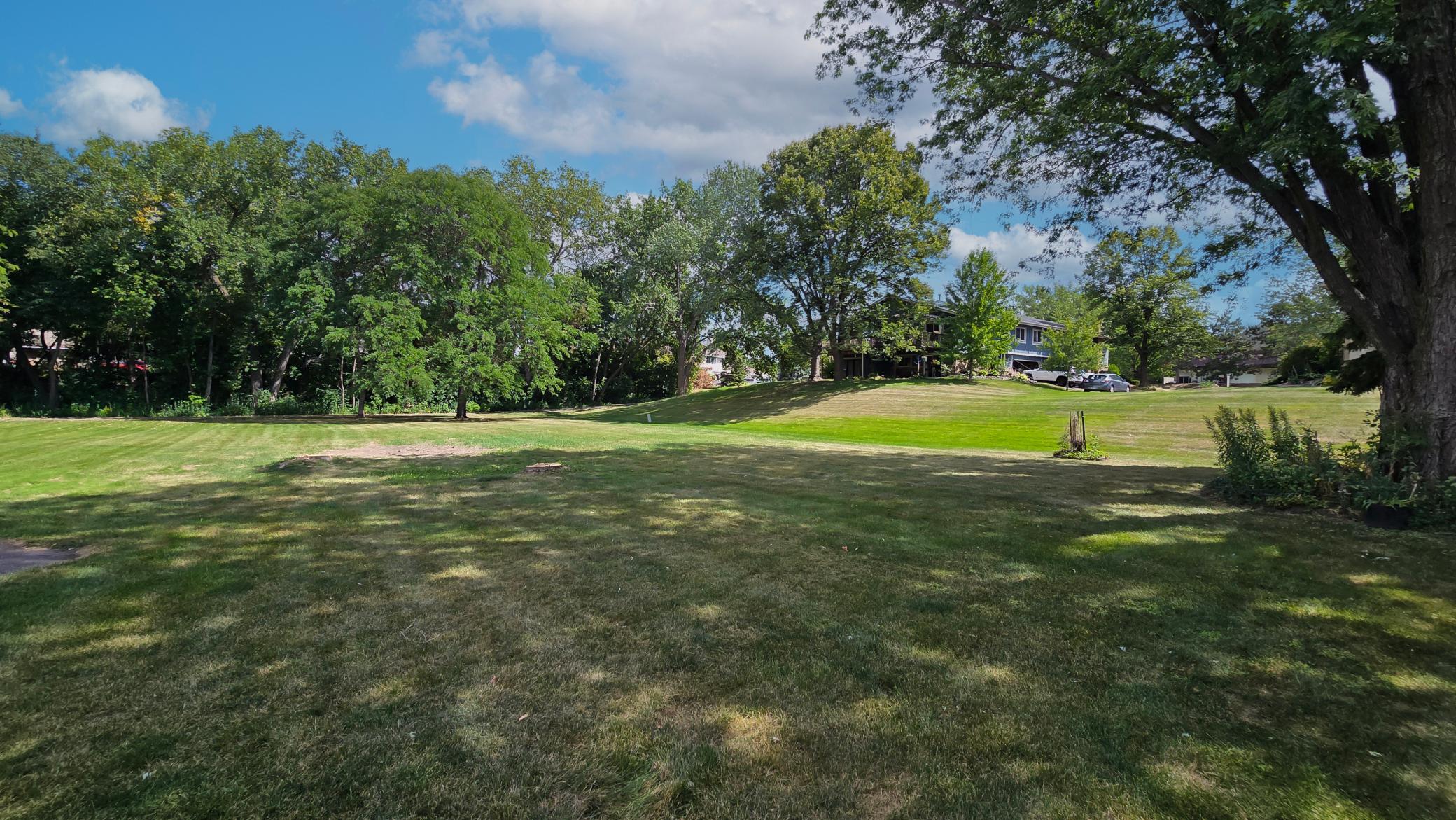 Enjoy endless outdoor possibilities on this sprawling, sunlit lawn surrounded by beautiful natural greenery.