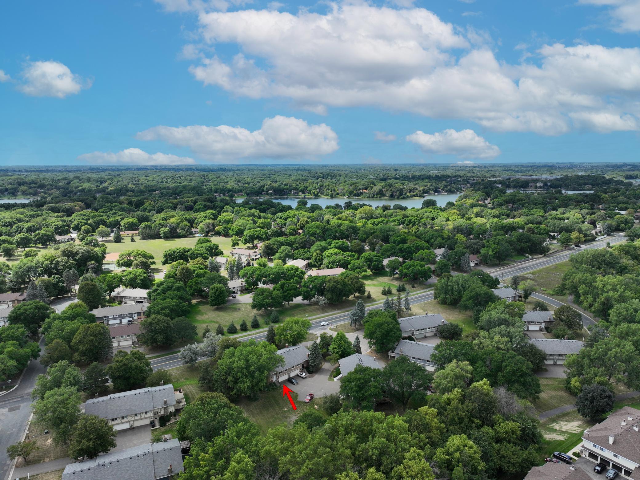 Elevated view showcasing the property's wooded surroundings and neighboring homes.