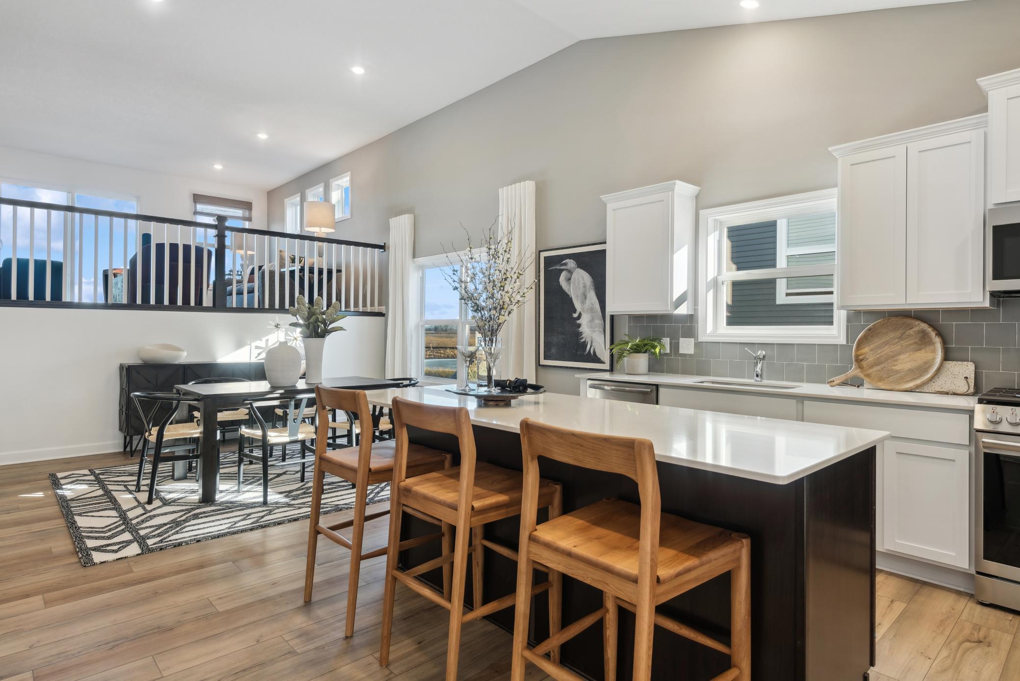(Photo of a decorated model, actual homes finishes will vary) The stunning kitchen provides a ton of cabinet space, an extra large kitchen island & a wonderful dining space large enough for a table to fit up to 8 at least.