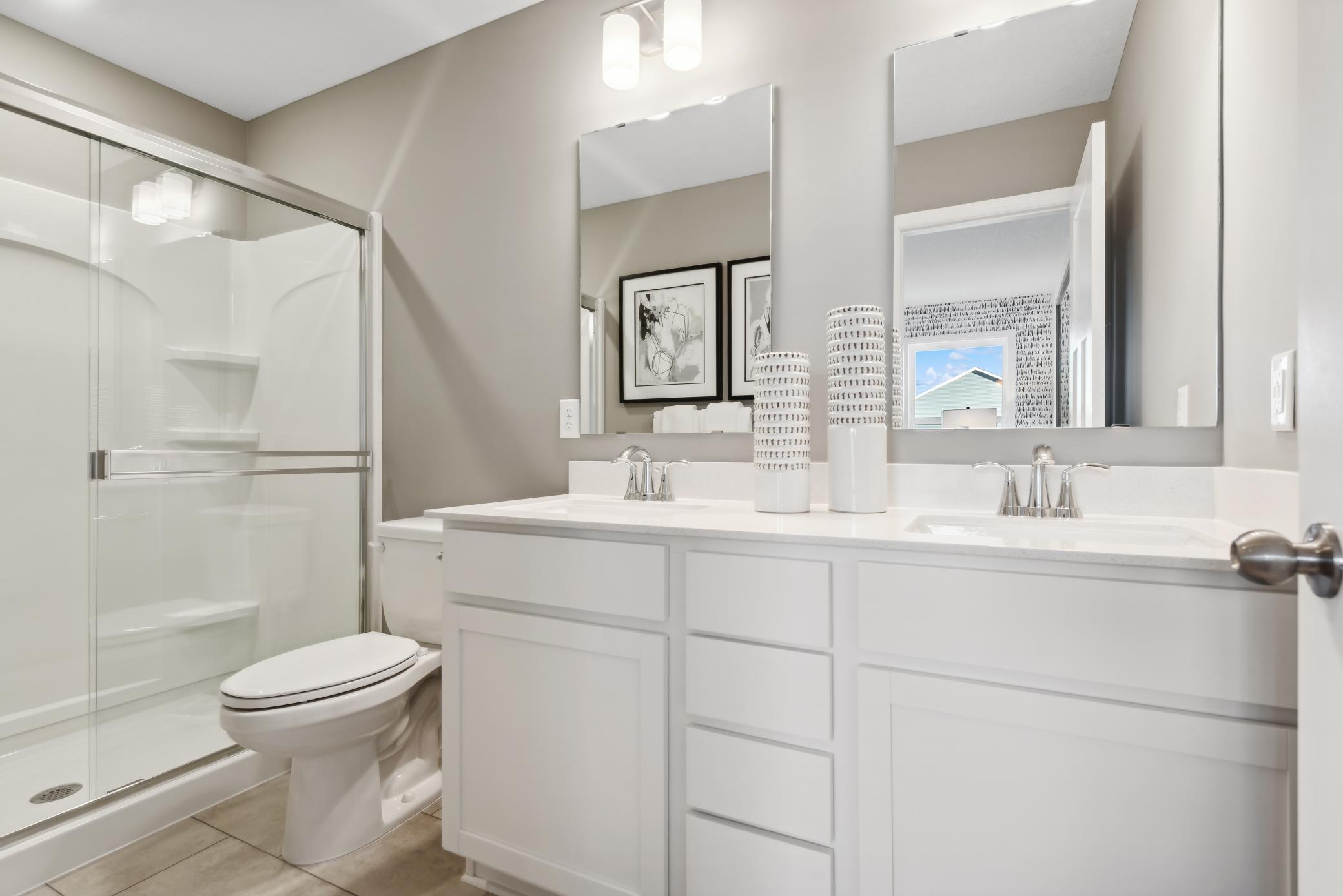 (Photo of a decorated model, actual homes finishes will vary) An extension of the primary bedroom, this private and spacious bath includes a double vanity and shower.