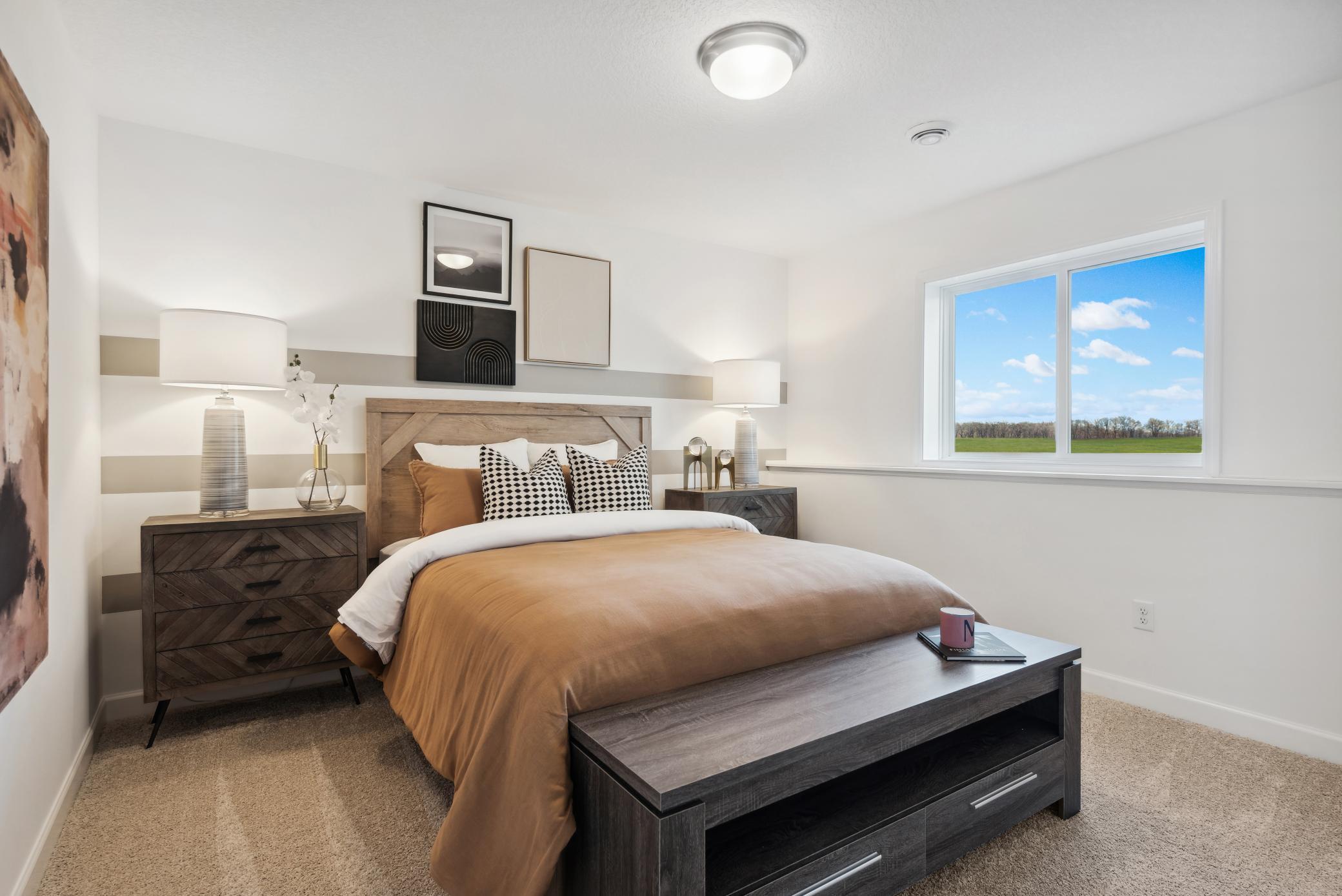 (Photo of a decorated model, actual homes finishes will vary) The lower level bedroom.