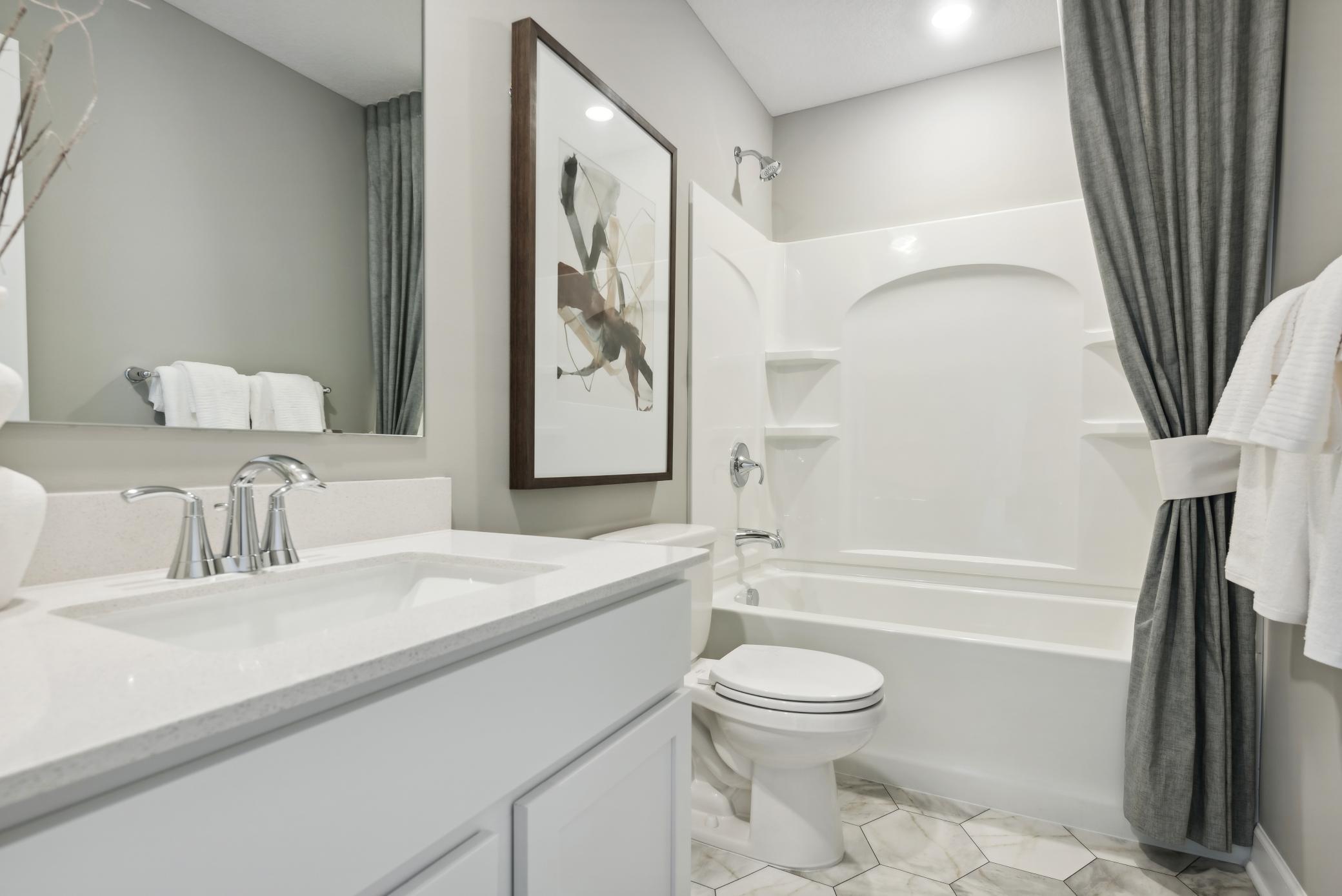 (Photo of a decorated model, actual homes finishes will vary) Lower level bath.