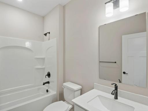 This full-sized bathroom is between the secondary bedrooms and features a single vanity and a shower-tub combination.