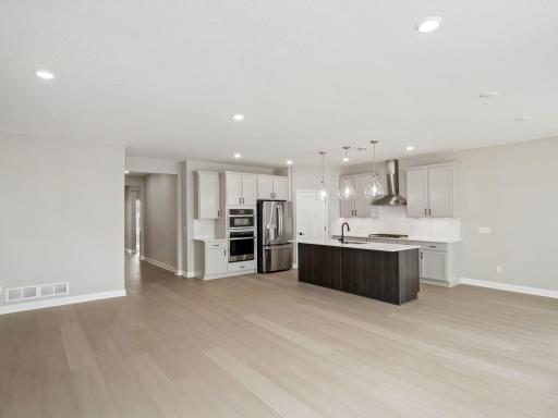 The center island with an undermount stainless steel sink and multicycle dishwasher effortlessly flows to the rest of the home for effortless living