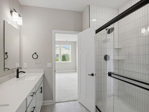 The glass-enclosed shower with full tile surround adds to a spa-like environment