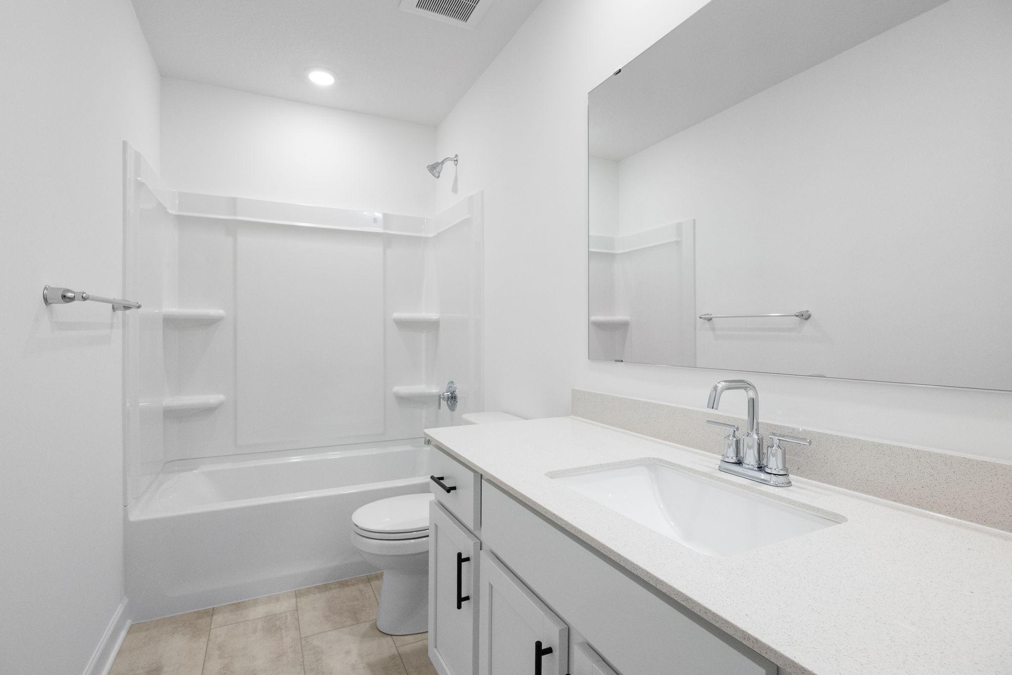 A full-sized bathroom on the second floor comes well-equipped with a generously sized quartz-topped vanity and a combination shower and tub to maximize the interior space.