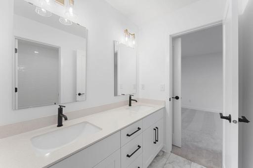 This Jack-and-Jill bathroom connects two bedrooms on the second floor, complete with dual sinks to accommodate seamless shared living.