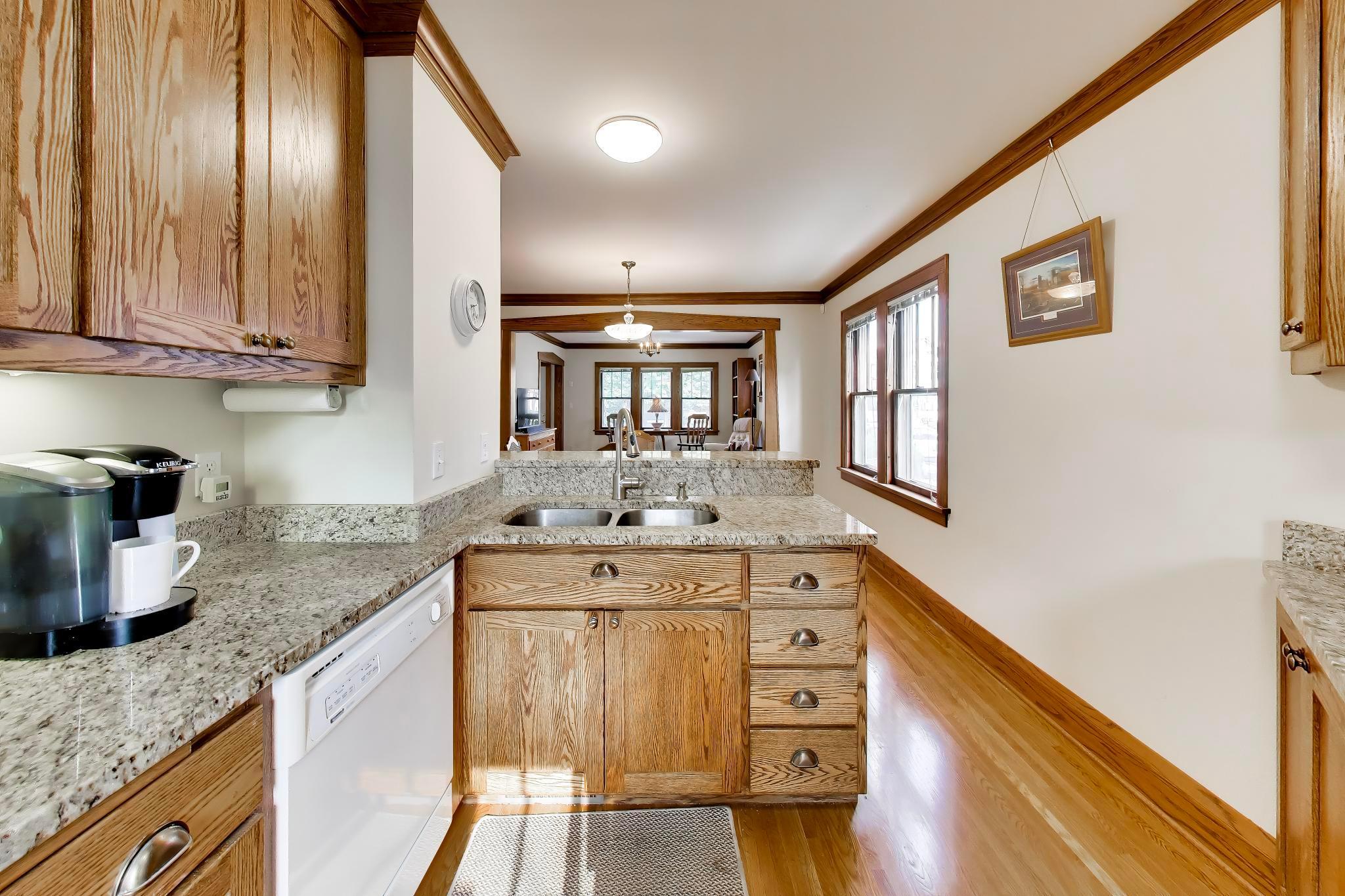 Wall was removed to open up the space, add a breakfast bar, and the wood flooring was skillfully and seamlessly extended into the kitchen.