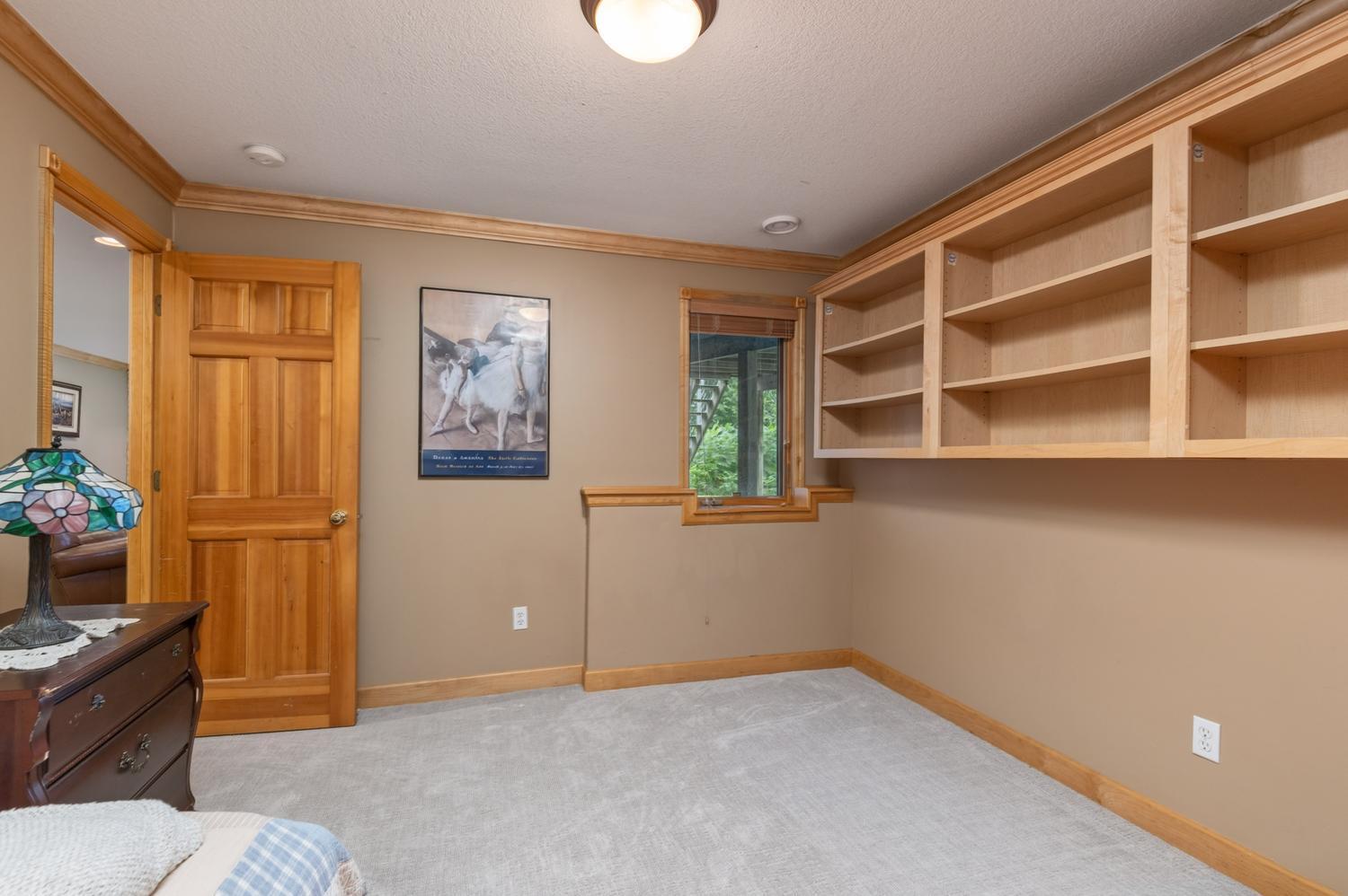This is the 5th bedroom in the lower level. This bedroom has the newer plush carpeting, custom book shelves and an egress window.