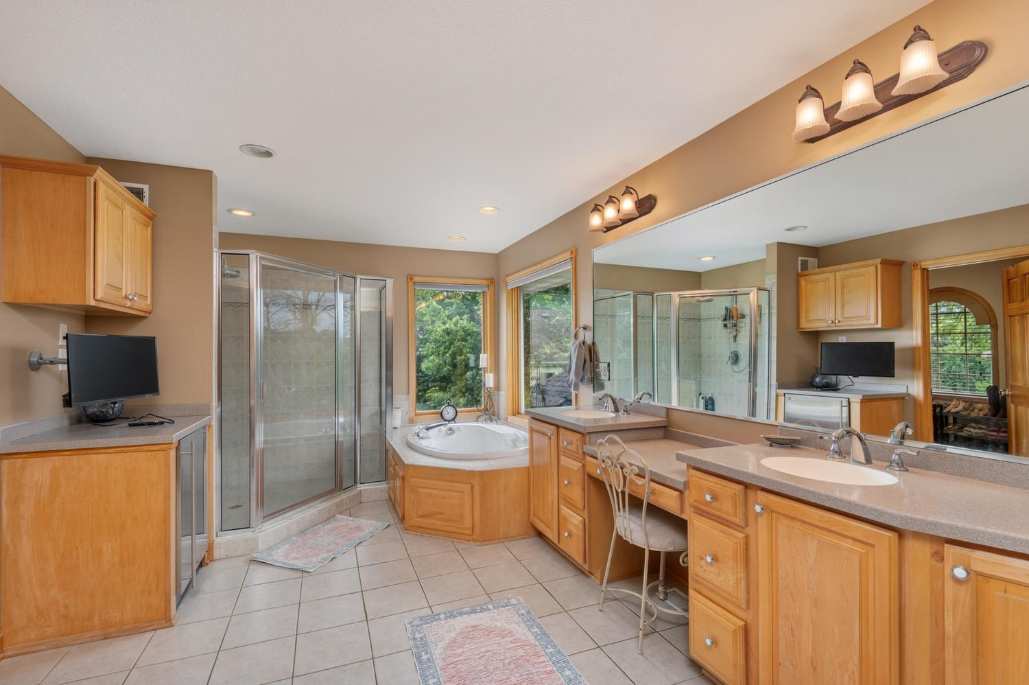 The primary is very spacious and includes a two sinks plus a makeup vanity and heated tile floor. There is also a beverage fridge and TV.