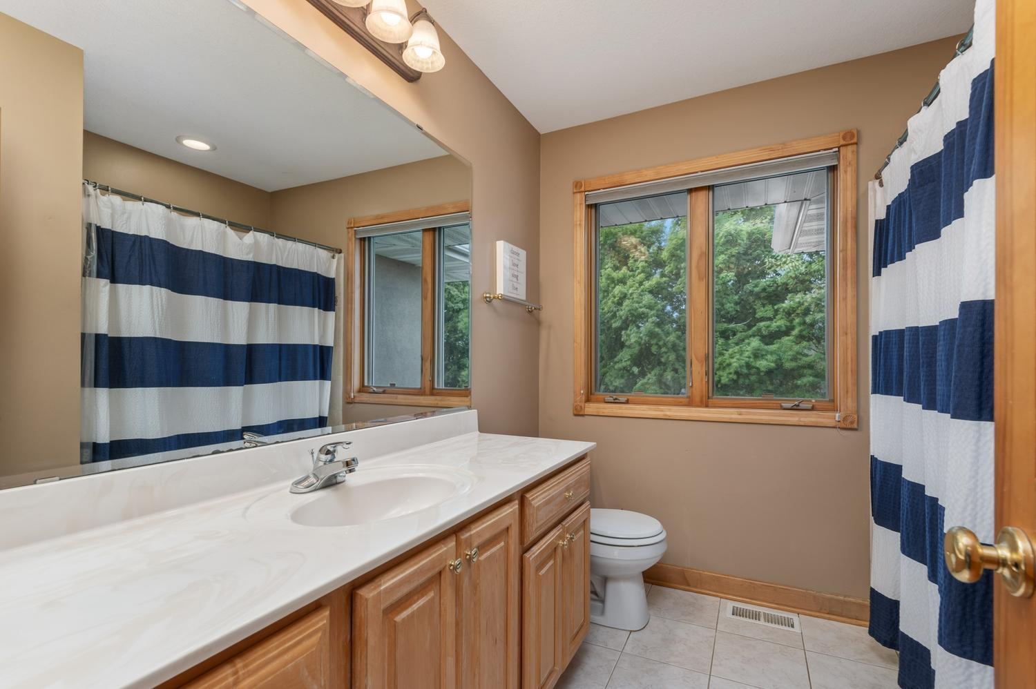 There is a spacious ceramic tile full bath off the hallway. The window views the back yard and lake.