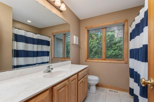 There is a spacious ceramic tile full bath off the hallway. The window views the back yard and lake.