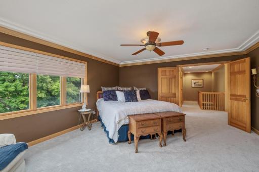 A pair of 6 panel wood doors step into the very spacious primary bedroom suite. The ceiling is finished with cove molding and ceiling fan.