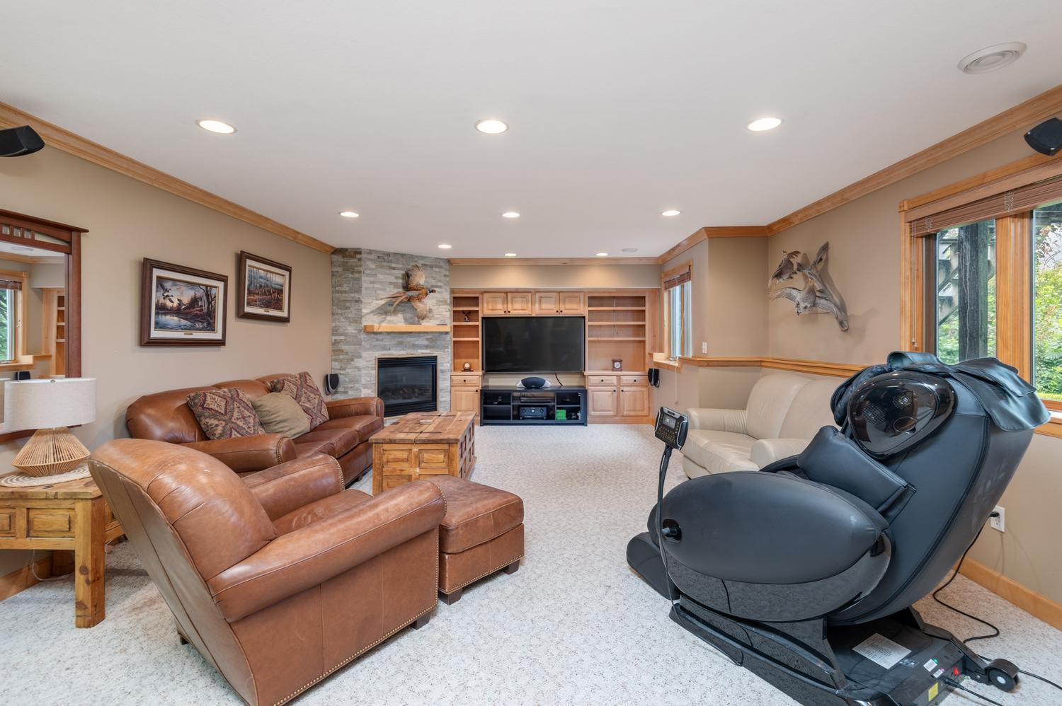 The lower level offers a bright amusement room with a gas fireplace finished in natural stone. Custom built ins have room for a large TV plus surround sound speakers.