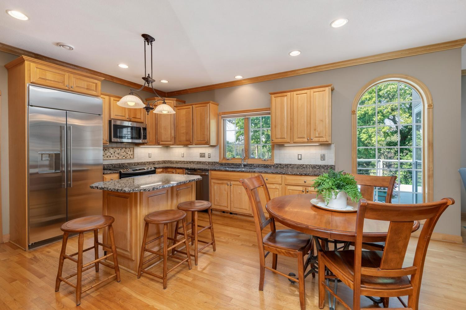 The kitchen offers tons of natural wood cabinetry and granite counter space. Updated GE stainless appliances include a GE Monogram refrigerator.