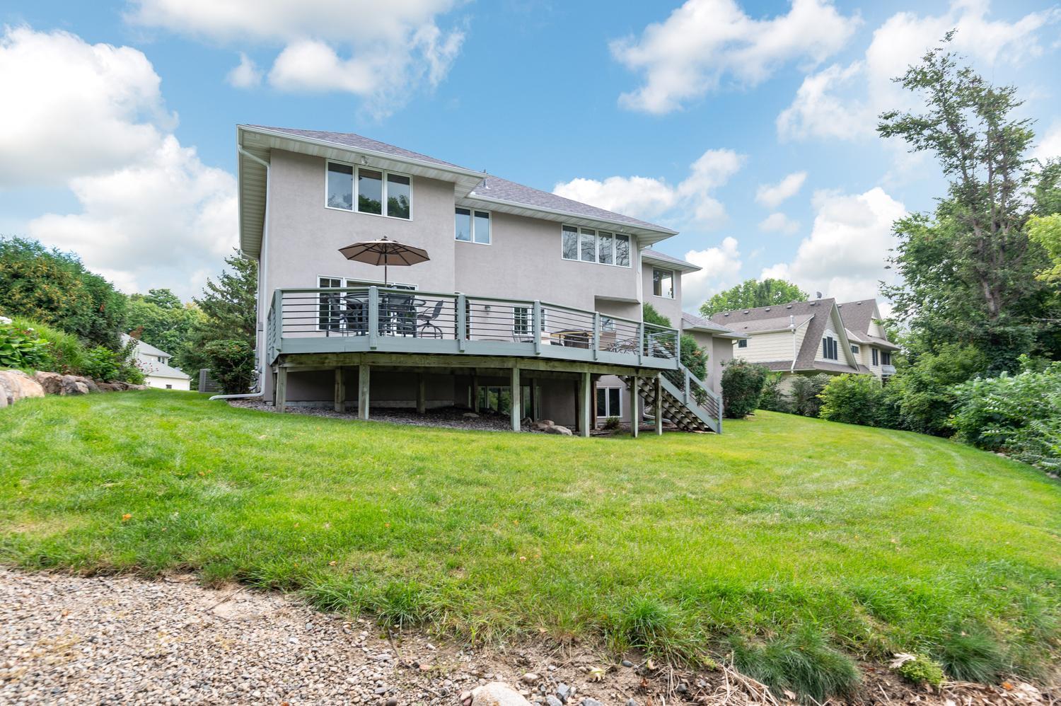 A very nice look on the back side of the home. The lawn has an in ground sprinkler system. The gravel path to the lake begins here.