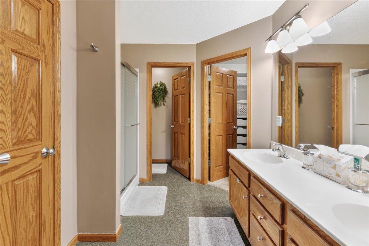 Private primary bathroom with large walk-in closet and step-in shower
