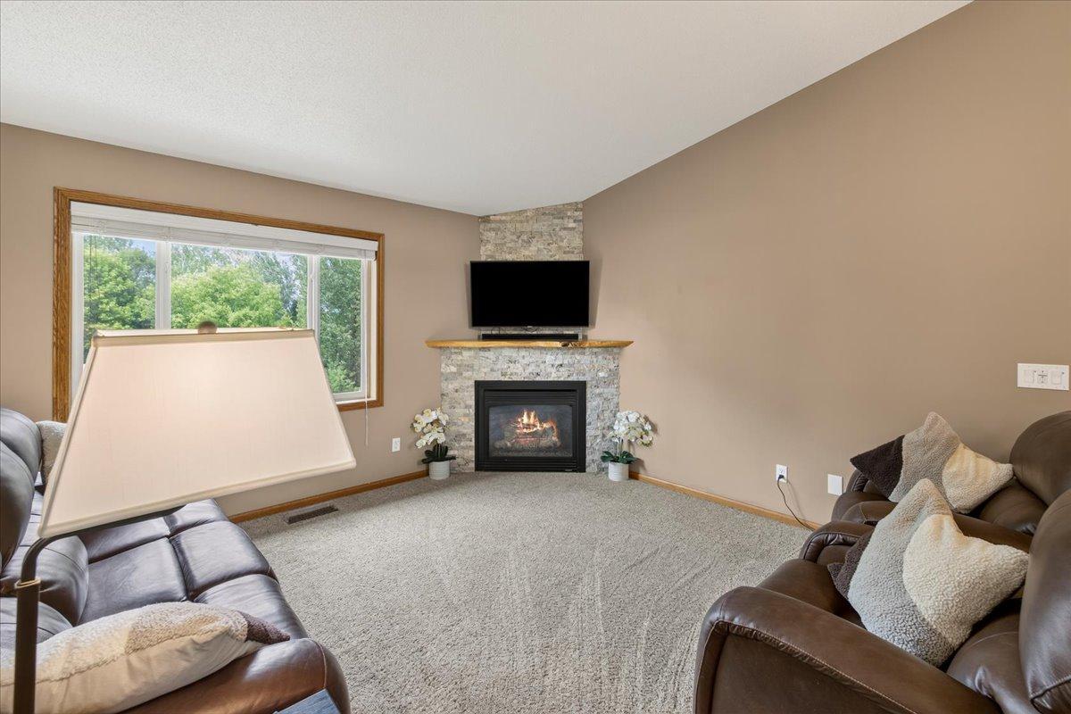 Stone gas fireplace with custom wood mantle in main level living room